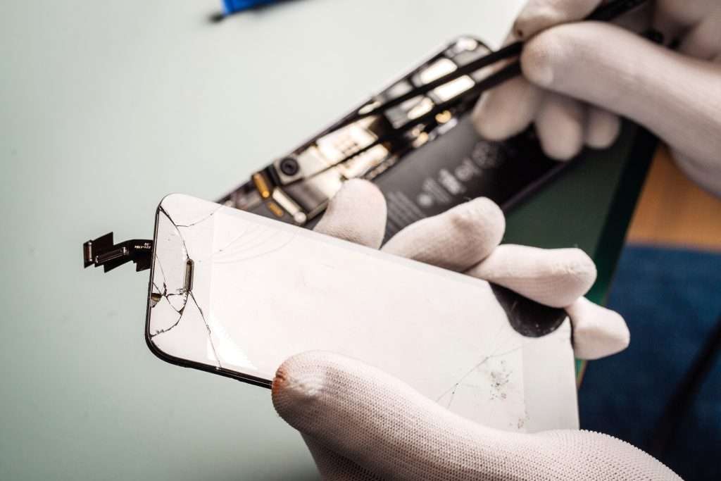 Riparazione iPhone: tecnico sostituisce un componente interno dello smartphone